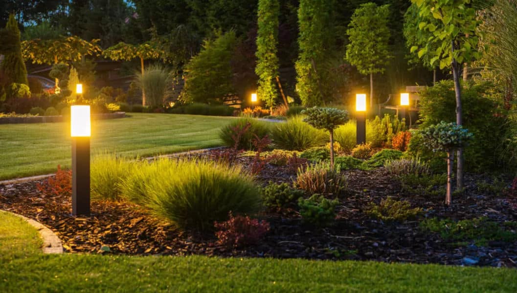 gros plan sur des luminaires posés en bordure de jardin